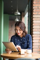 Beautiful cute asian young businesswoman in the cafe, using digi