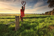 Escape to the Country - female on fence with love heart in morni