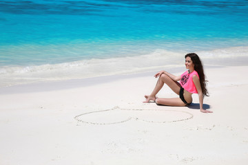 Sticker - Carefree bikini model girl with heart on sand relaxing on exotic