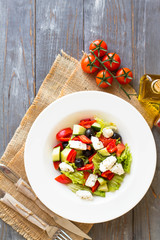 Wall Mural - Greek salad with fresh vegetables, feta cheese and black olives. Top view