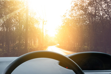 Inside car view ,steering wheel on blur traffic road with colorful bokeh light abstract background.