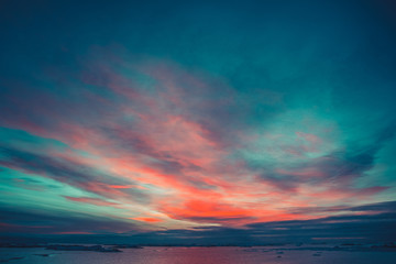 Wall Mural - summer sunset in antarctica. dramatic colourful cloudy sky above ocean and glaciers. beautiful natur