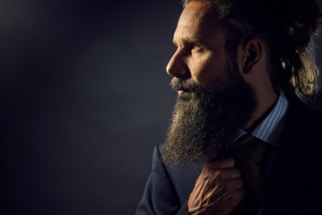 Bearded Man in suite and tie in front of gray background