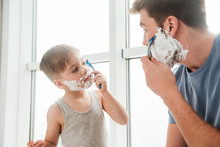 Father And Son Are Shaving In Bathroom