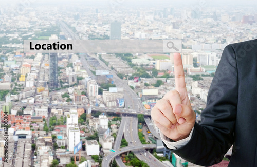Fotografía Businessman hand pointing location search bar over blur city