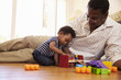 © Monkey Business - Grandfather And Grandson Playing With Toys On Floor At Home