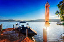 Morning Sun Behind Umbrella On Lakeside Dock