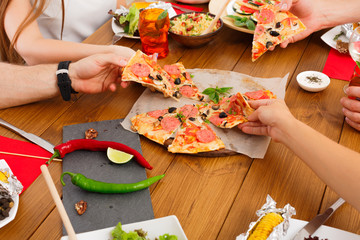 Wall Mural - People eat pizza at festive table dinner party