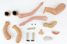 Doll Body Parts On A White Background.