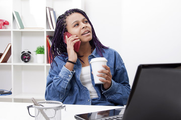 young woman with mobile phone and laptop computer