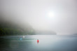 © Richard Schultz - Young boy with swimming wings in a large lake with mountains in the background. Maine