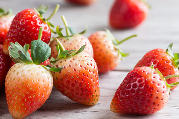 Wall Mural - Strawberries with leaves on a wooden background