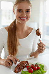 Wall Mural - Woman Eating Food. Beautiful Female Eating Meat With Vegetables