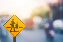 School Zone Warning Sign On Blur Traffic Road With Colorful Bokeh Light Abstract Background.