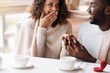 © Viacheslav Yakobchuk - Merry young African American couple getting engaged in the cafe