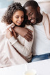 © Viacheslav Yakobchuk - Delighted young African American couple sitting and hugging