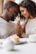 © Viacheslav Yakobchuk - Soulful smiling African American couple touching hands in the cafe