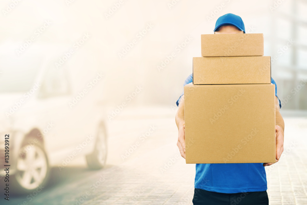 delivery man holding pile of cardboard boxes in front. copy spac - obrazy, fototapety, plakaty 