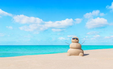 Poster - Positive sandy snowman in sunglasses at sunny tropical ocean beach