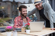© Fergus Coyle - Gay couple sat sharing laptop outside cafe