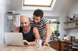 © Fergus Coyle - Gay couple using laptop in the kitchen