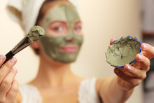 Woman Applying With Brush Clay Mud Mask To Her Face