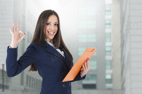 Fotografía women's business attractive with the dossier and the sign of approval and okay s