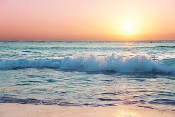 Sunset light catches the top of a wave on Grand Cayman's Seven Mile Beach