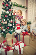 © Dalibor Danilovic - Little girls decorating Christmas tree and preparing gifts