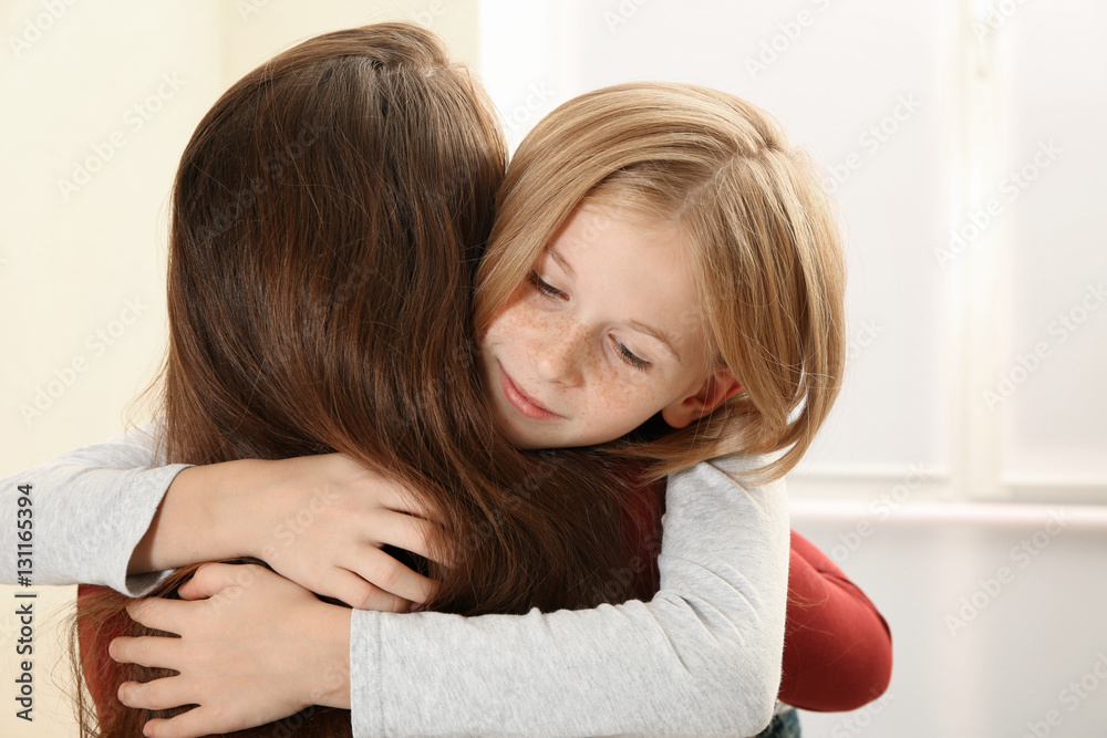 Woman becalming little sad girl, closeup