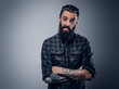 © Fxquadro - Bearded male with tattoos on his arms.