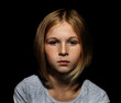 © Africa Studio - Portrait of sad little girl on black background