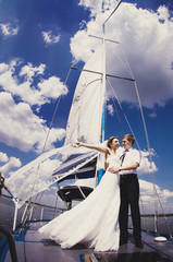 vertical photo newly married couple stand on white yacht, outdoo