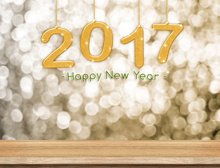 Poster - 2017 new year hanging over plain wood table top with gold sparkl
