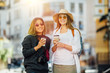 © mintybear - tourism, travel, leisure, holidays and friendship concept - smiling teenage girls with camera and coffee to go outdoors