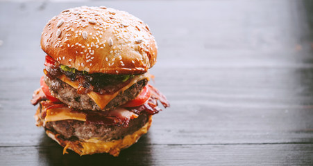 Wall Mural - tasty and delicious juicy burger with beef and bacon on a grill