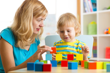 Wall Mural - Child together with mother playing educational toys