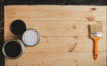 Two Paint Cans And Brush On Wooden Background With Copy Space In Center, Top View