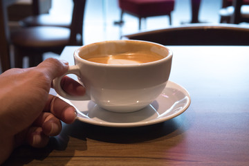 Hot coffee in white cup in hand