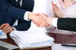 © rogerphoto - Business people shaking hands finishing up a meeting