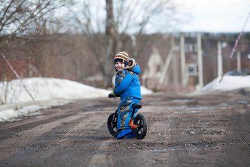 Child in ride balance bike (run bike) at winter