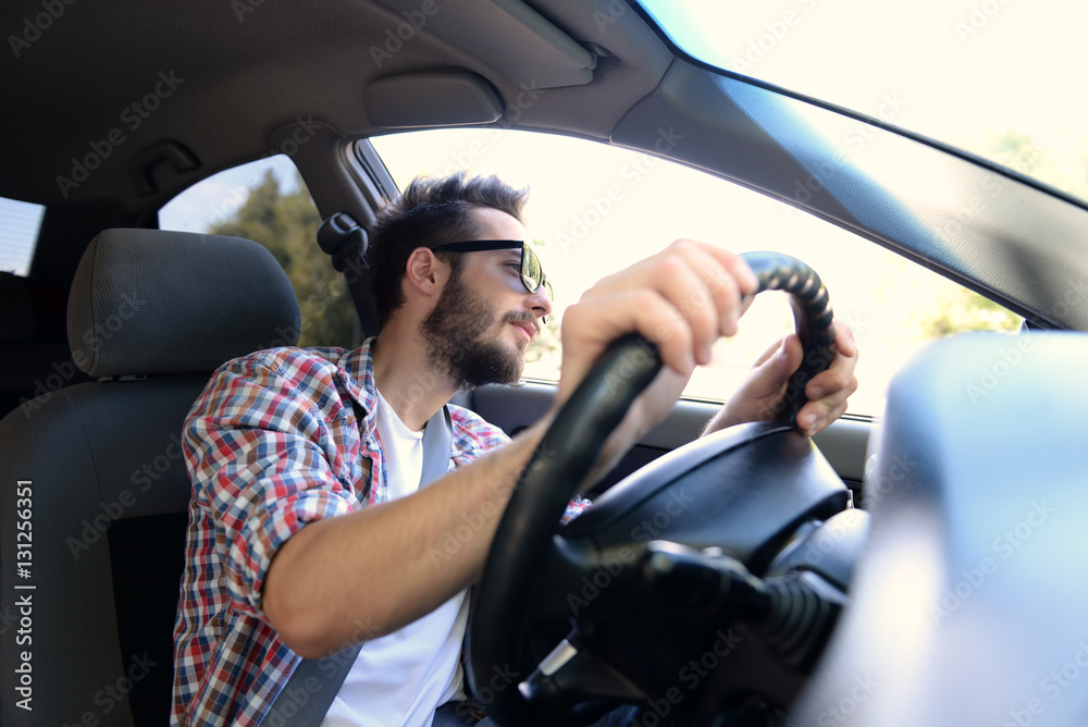 Portrait of successful young man driving car