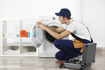 Wall Mural - Plumber repairing washing machine