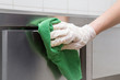 canvas print picture - Hand in protective glove with rag cleaning kitchen equipment in the professional kitchen. Stainless steel surface. Early spring cleaning or regular clean up.