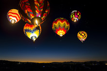 Colorful Hot Air Balloons At Dawn Lit Up In The Sky.