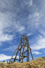 Old Mining Head Frame In The Nevada Desert Under Blue Sky With Clouds.