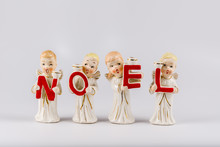 Antique Ceramic Christmas Caroler Angels On A Grey Background