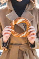 Wall Mural - Beautiful woman holds a traditional Turkish simit in hands and w