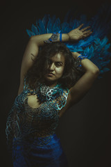 Wall Mural - Beautiful latina woman in blue feather bird costume, fantasy and