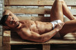 Handsome muscular man on wooden bench